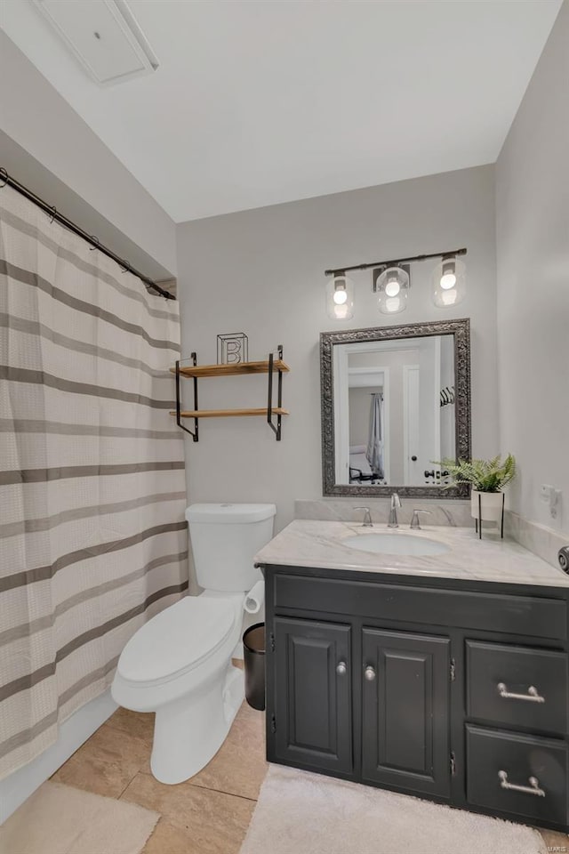 bathroom featuring tile patterned flooring, toilet, and vanity
