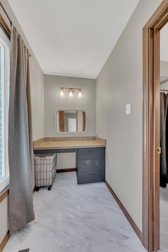 bathroom featuring marble finish floor, baseboards, and vanity