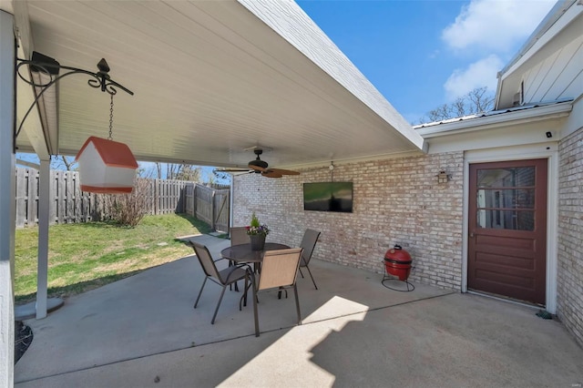 view of patio featuring outdoor dining space, fence, and a ceiling fan