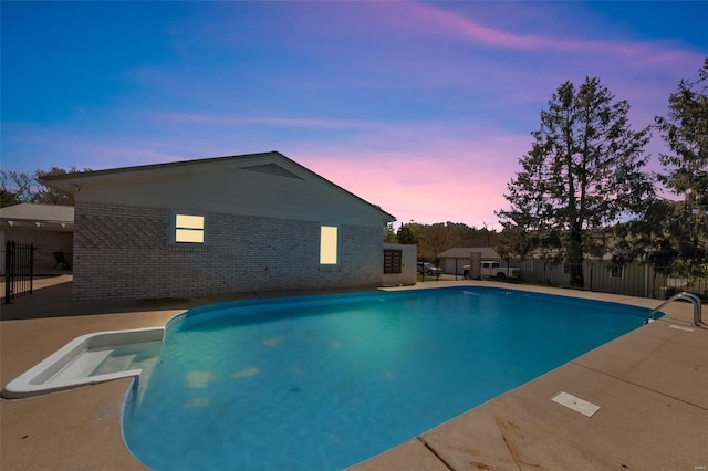pool at dusk featuring fence and a fenced in pool