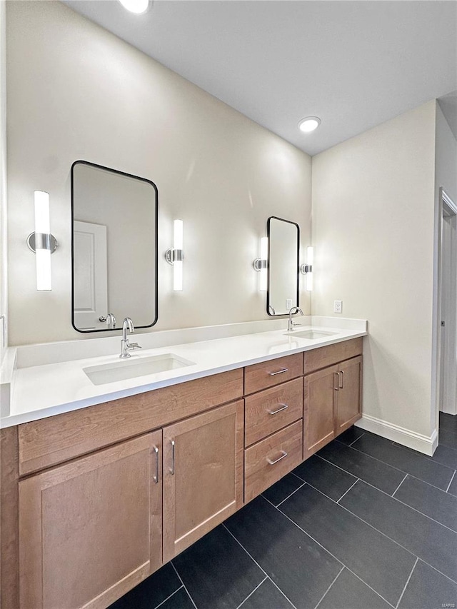 full bath with tile patterned floors, double vanity, a sink, and baseboards
