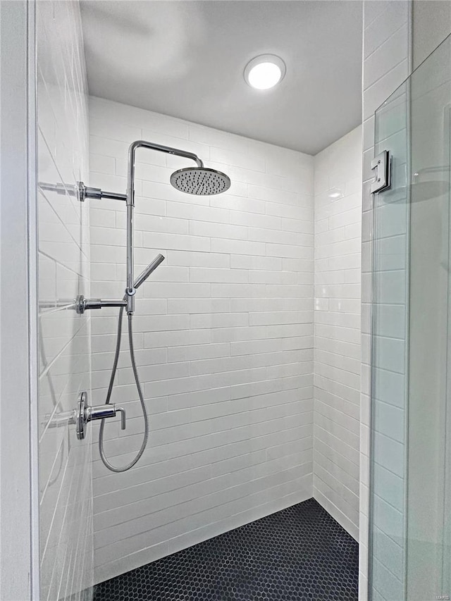 bathroom with a shower stall and tile patterned flooring
