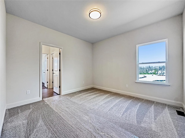 carpeted empty room with baseboards