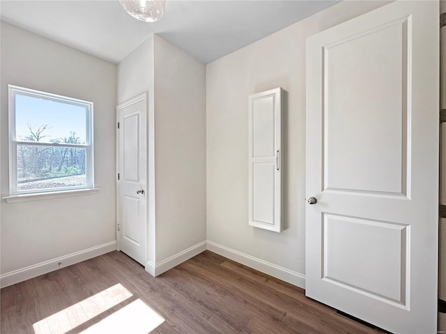 unfurnished bedroom with wood finished floors and baseboards