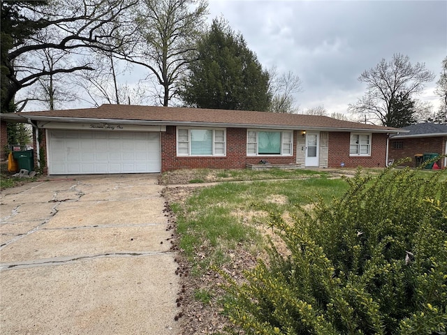 single story home with concrete driveway, brick siding, and an attached garage