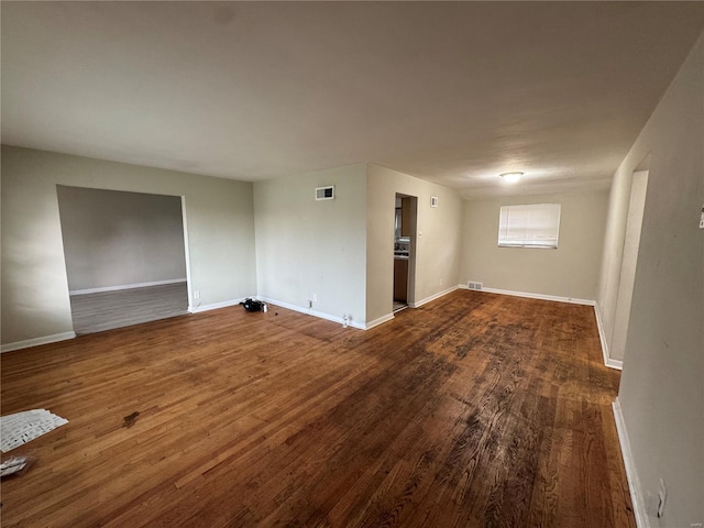 spare room featuring wood finished floors, baseboards, and visible vents