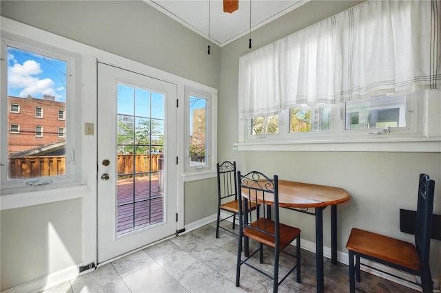 doorway with tile patterned floors, baseboards, and ornamental molding