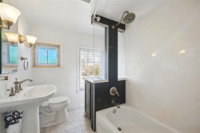 bathroom with marble finish floor, toilet, a sink, and shower / washtub combination