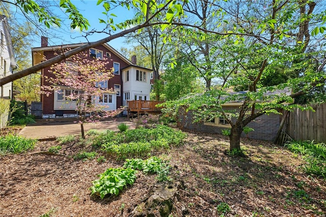view of yard with a wooden deck, fence, and a patio area