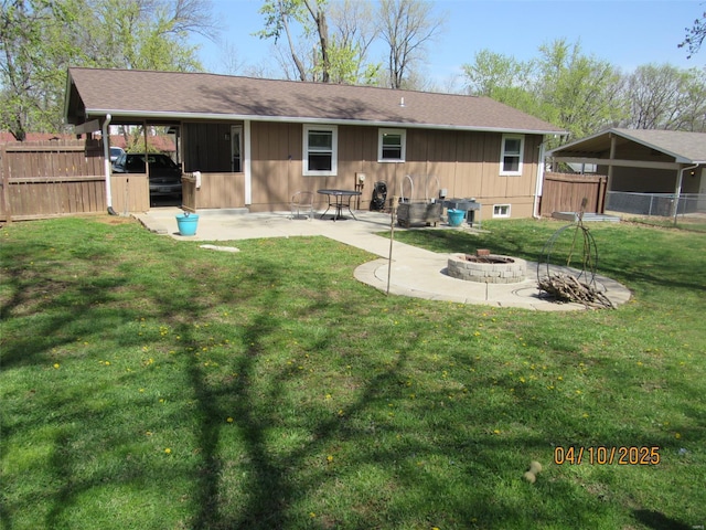rear view of property with a patio, fence, a fire pit, and a lawn