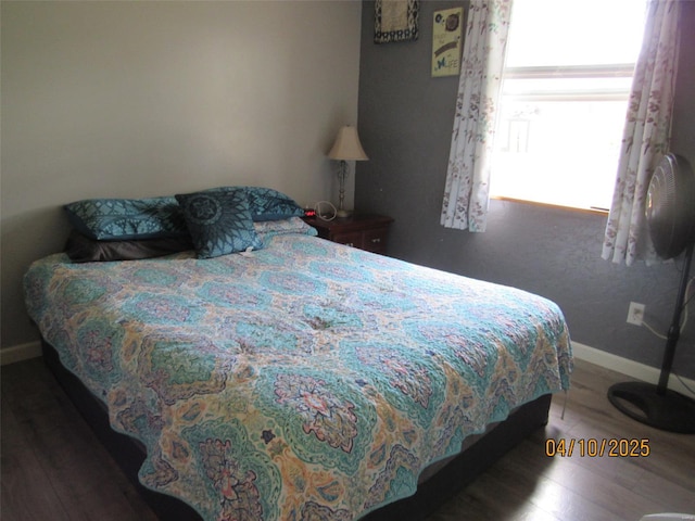 bedroom with wood finished floors and baseboards