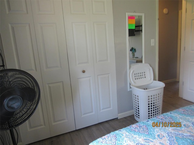 bedroom featuring a closet, baseboards, and wood finished floors