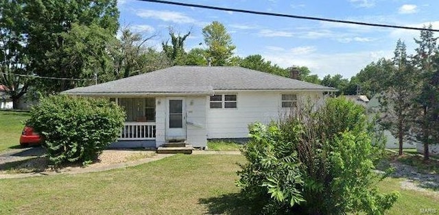 rear view of property featuring a lawn