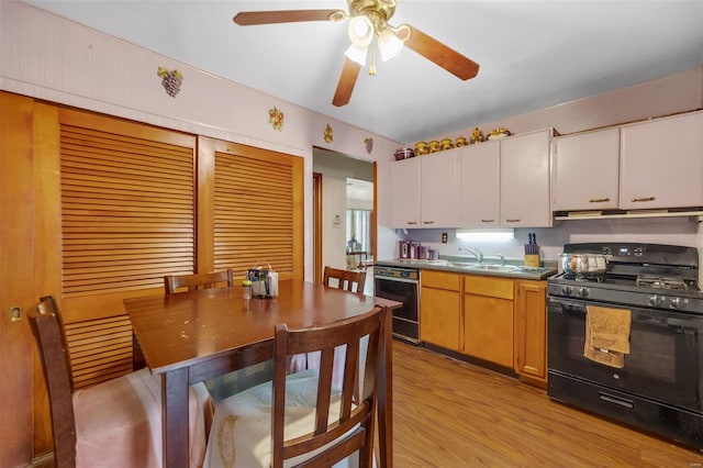kitchen with black range with gas cooktop, a ceiling fan, extractor fan, dishwasher, and light wood-style flooring