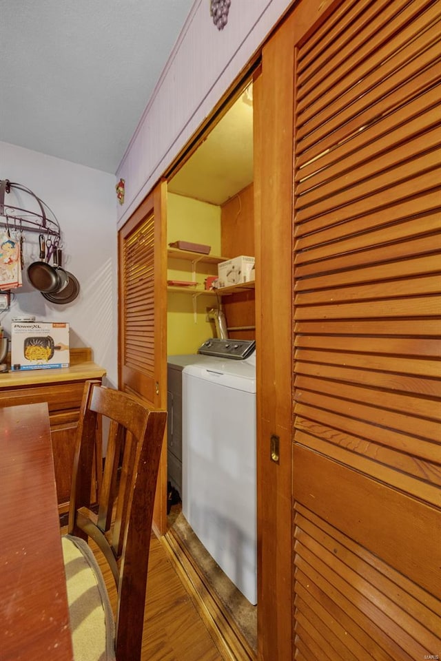 washroom with a dry bar, light wood-style flooring, washer and clothes dryer, and laundry area
