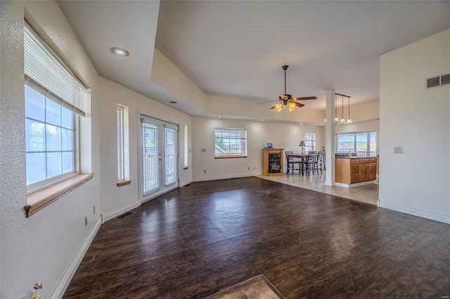 unfurnished living room with visible vents, baseboards, a ceiling fan, and wood finished floors