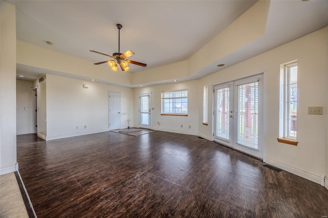 unfurnished living room featuring wood finished floors, visible vents, baseboards, and ceiling fan