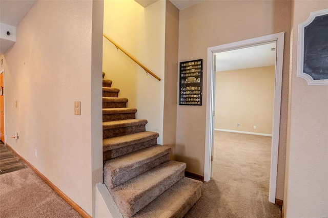 stairway with baseboards and carpet floors