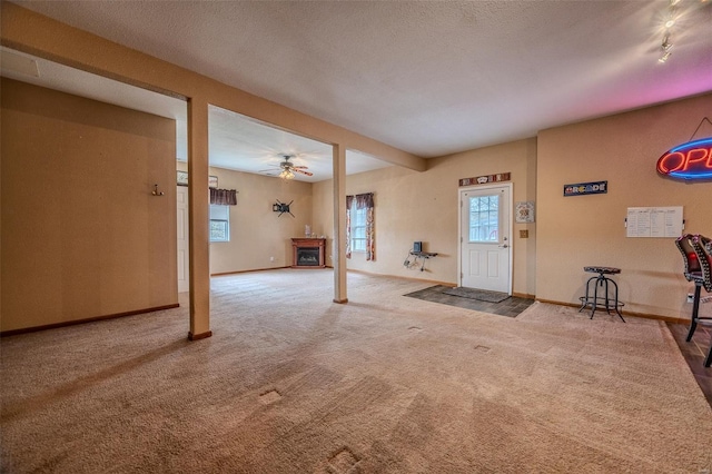 carpeted entrance foyer with ceiling fan and baseboards