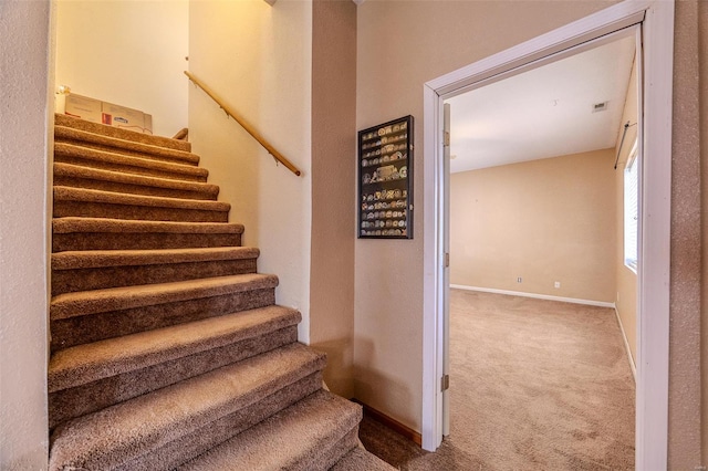 staircase with baseboards, carpet flooring, and visible vents