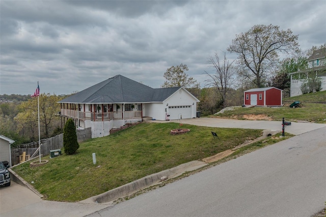 view of front of property featuring a front lawn, driveway, covered porch, fence, and a garage