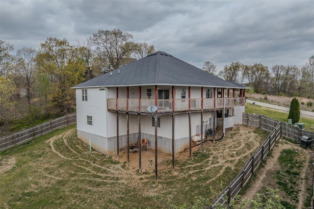 rear view of property featuring a lawn, a deck, and a fenced backyard