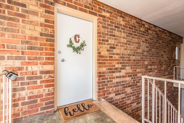 doorway to property with brick siding