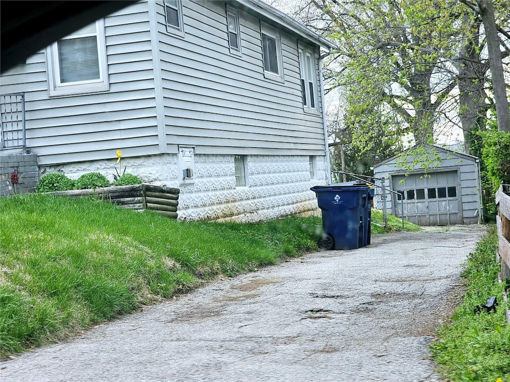 view of home's exterior with an outbuilding, a garage, and aphalt driveway