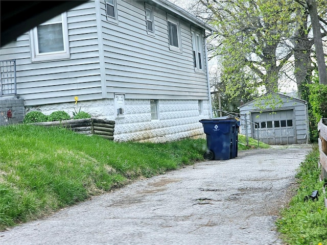 view of home's exterior with an outbuilding, a garage, and aphalt driveway