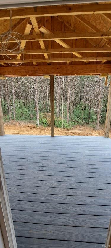 wooden deck with a wooded view