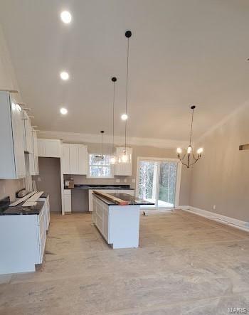 kitchen with white cabinets, dark countertops, pendant lighting, and baseboards