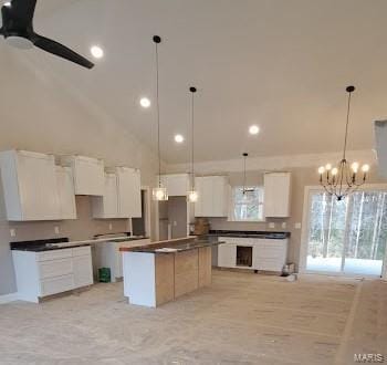kitchen featuring pendant lighting, dark countertops, high vaulted ceiling, a center island, and white cabinets