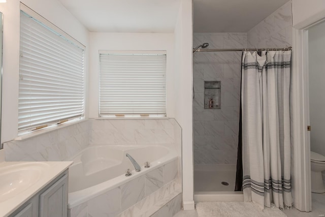 bathroom with vanity, toilet, a garden tub, and a stall shower