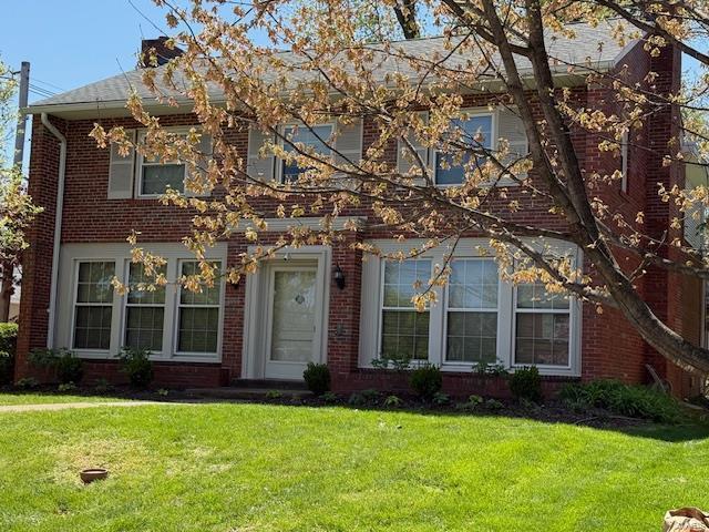 view of front of property featuring brick siding and a front yard
