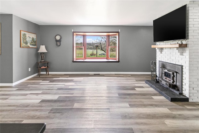 unfurnished living room with wood finished floors and baseboards