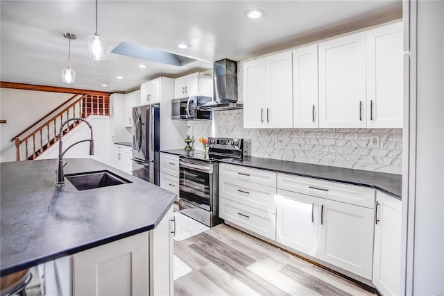 kitchen featuring dark countertops, a sink, wall chimney exhaust hood, and stainless steel appliances