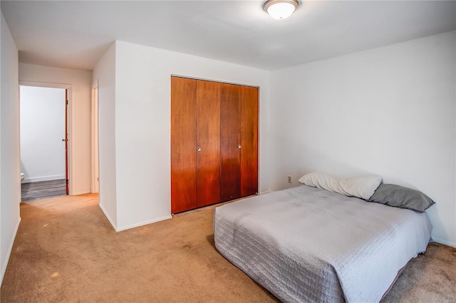 bedroom with a closet, carpet flooring, and baseboards