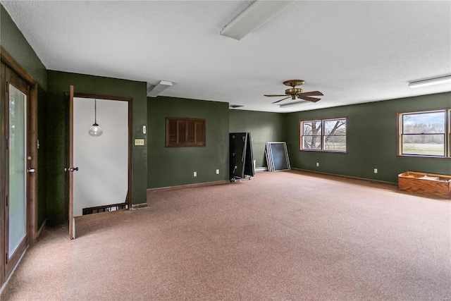 carpeted spare room with baseboards and a ceiling fan