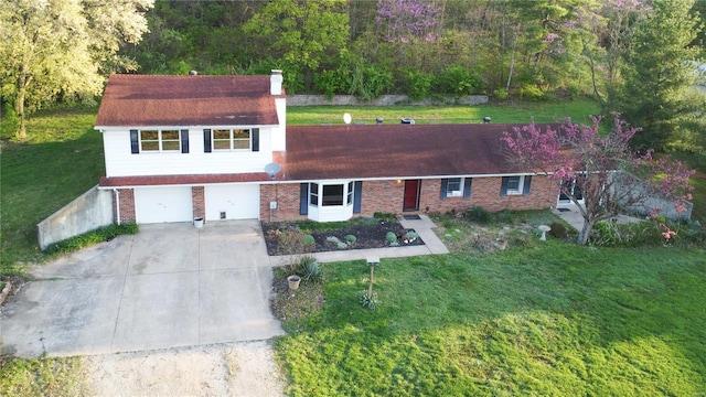 view of front of home with a front yard, a chimney, brick siding, and concrete driveway