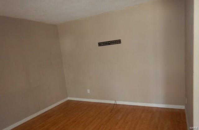 unfurnished room with baseboards and wood finished floors