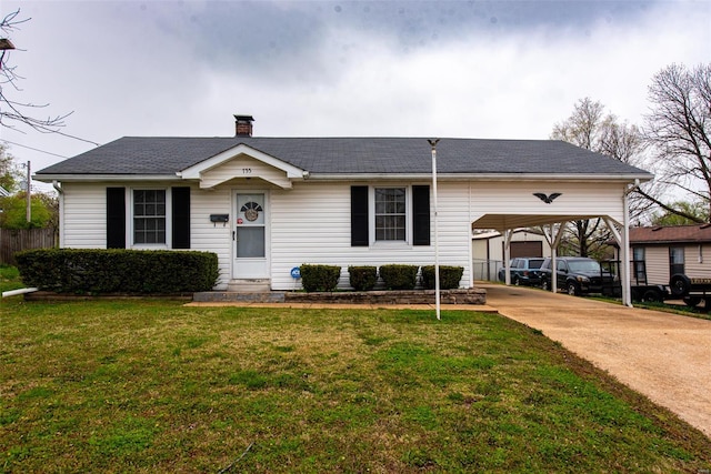view of front of home with a carport, driveway, a chimney, and a front lawn