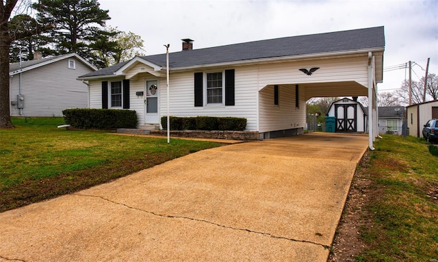 ranch-style house with a carport, an outdoor structure, a chimney, driveway, and a front yard