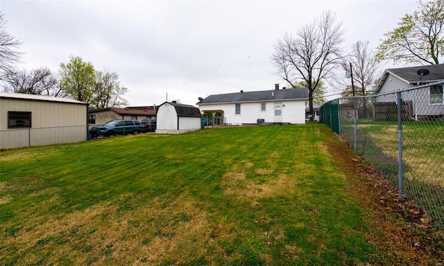 view of yard with a shed, fence, and an outbuilding