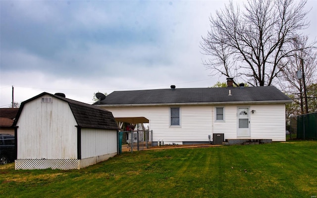 back of property with a yard, a storage shed, a chimney, fence, and an outdoor structure