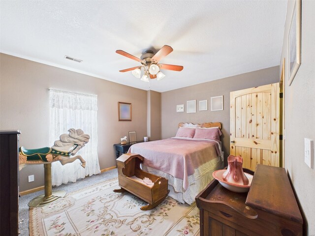 carpeted bedroom with visible vents, baseboards, and ceiling fan