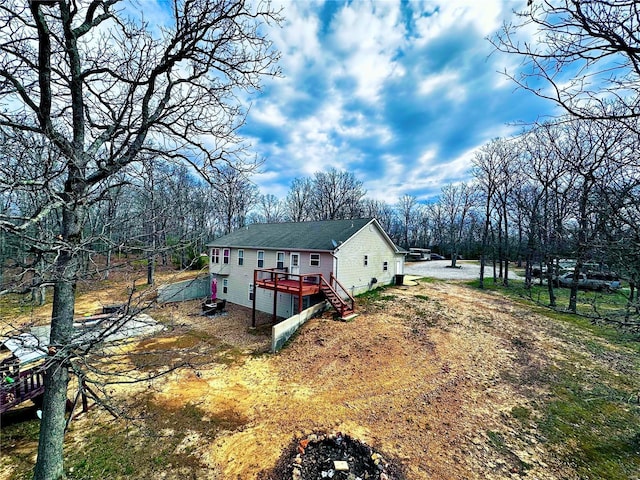 view of home's exterior with crawl space, a wooden deck, and stairway