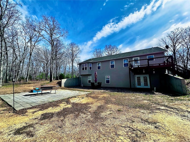 back of house with french doors, a deck, and a patio