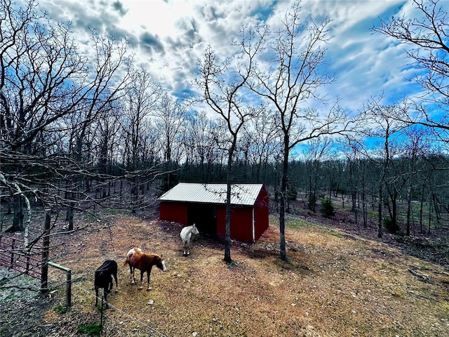 view of yard featuring a rural view, an outbuilding, and a storage unit
