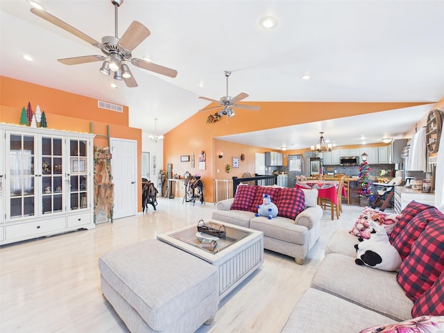 living area featuring light wood-type flooring, ceiling fan with notable chandelier, lofted ceiling, and visible vents