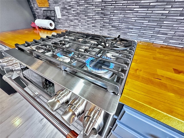 interior details featuring stainless steel range with gas cooktop and wood finished floors